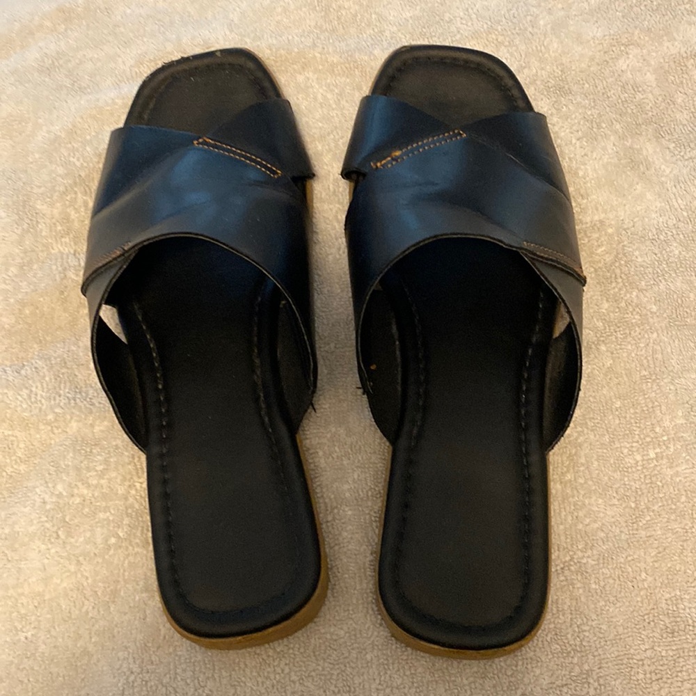 Coach and four black leather slides.